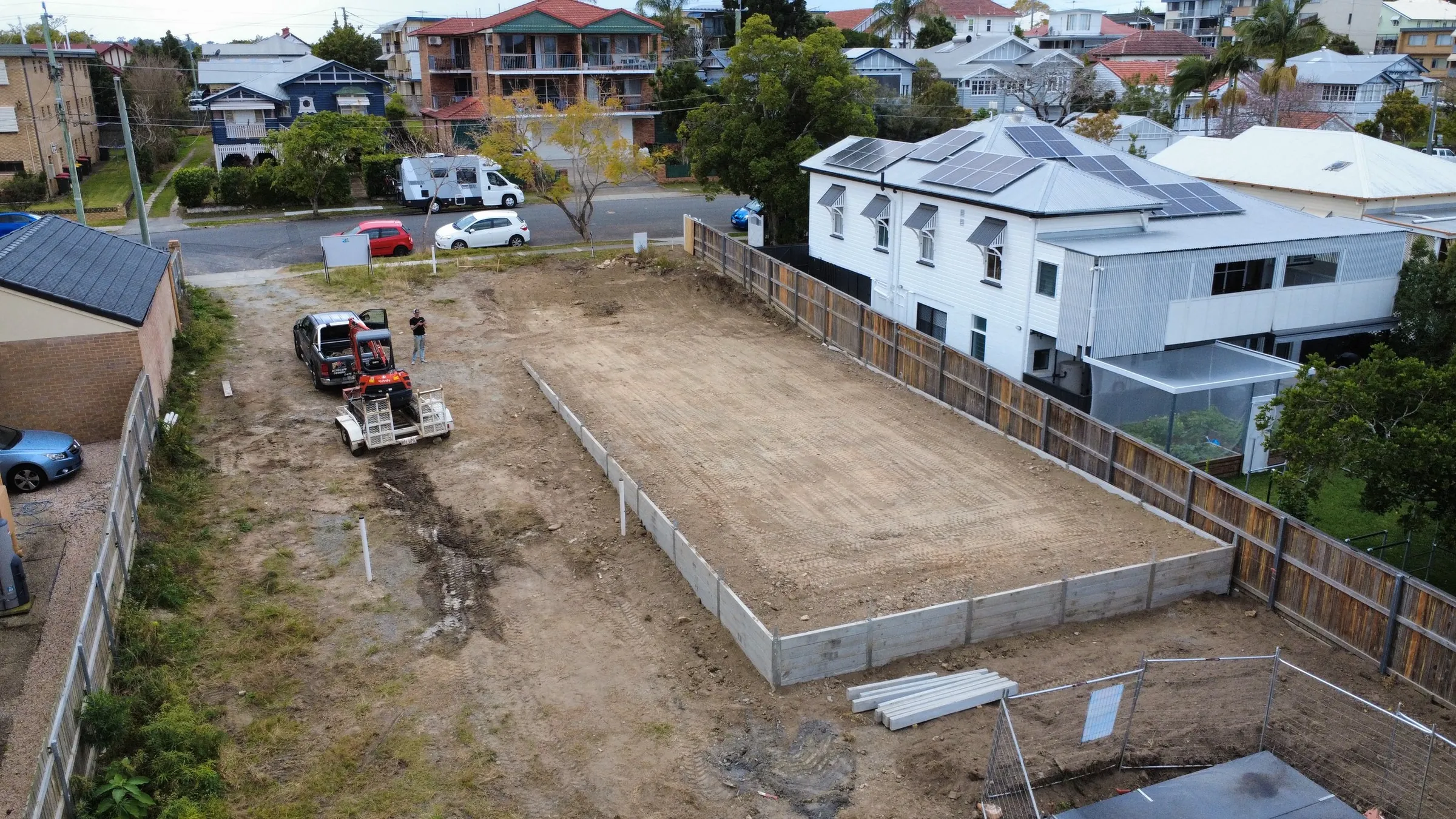 Drone view of a level house pad framed by concrete sleeper walls