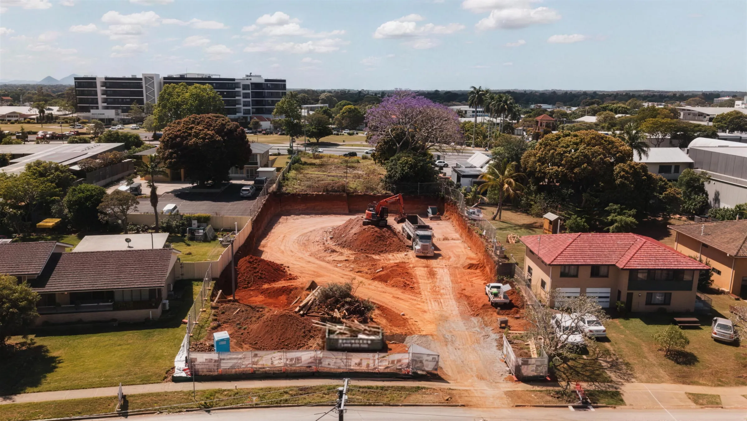 Aerial view of a fenced site cut on a suburban street