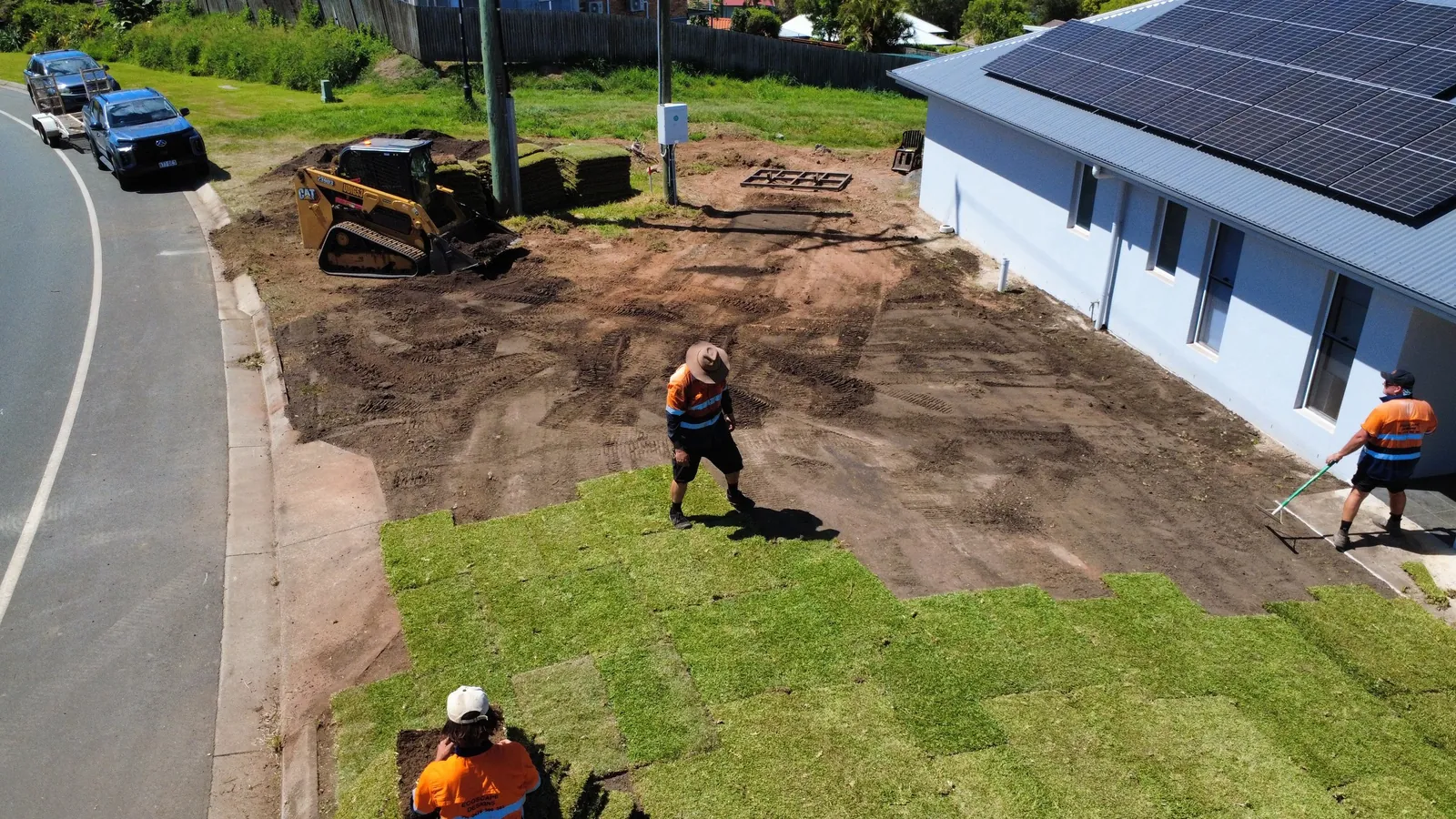 Drone view of the crew laying new turf with a posi track on site