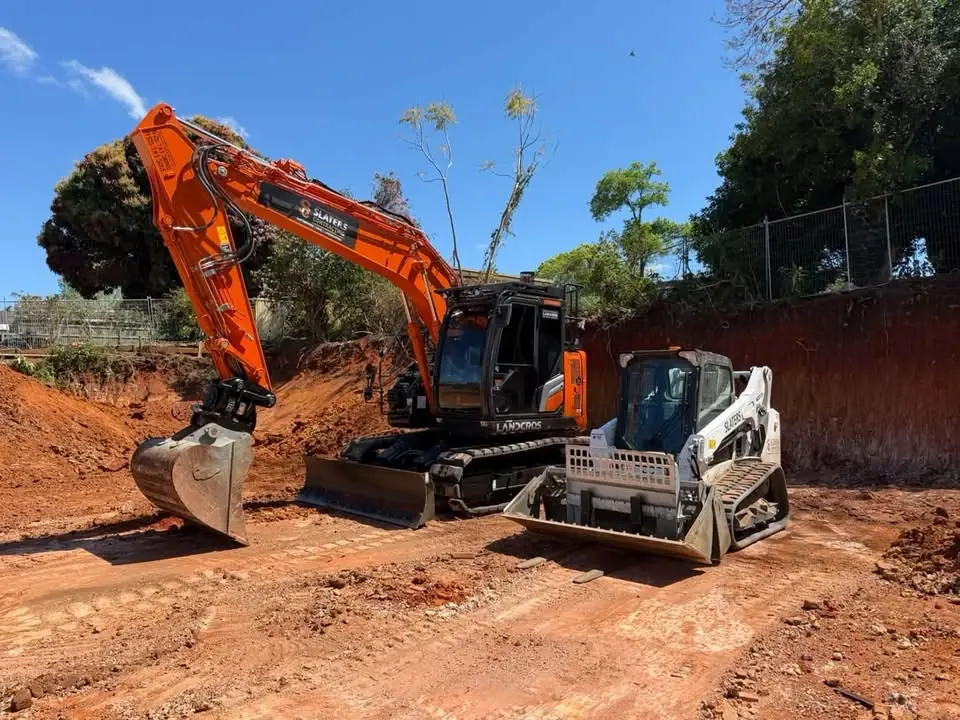 Slaters excavator and posi track on a red-dirt site cut