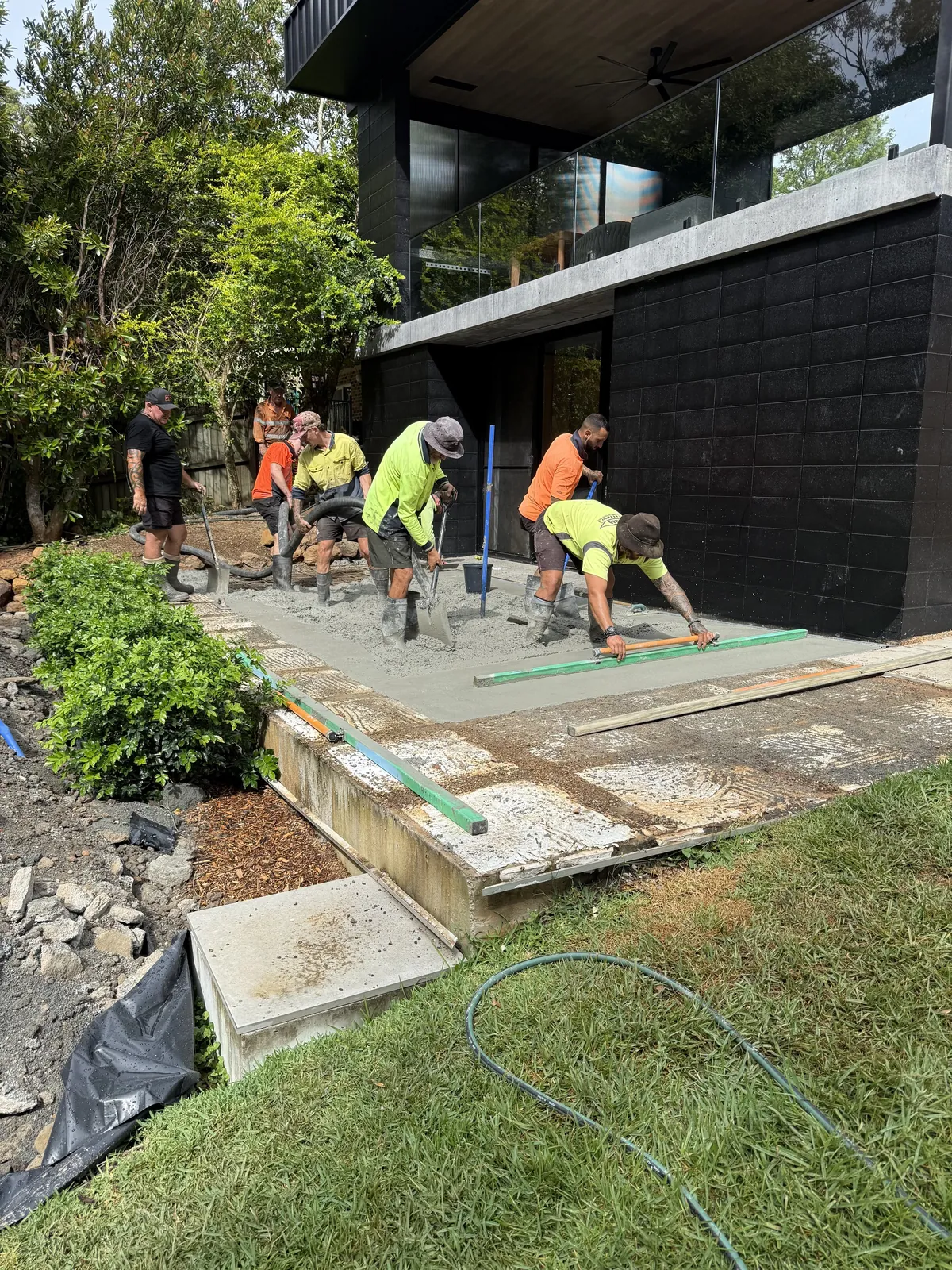 The crew working on paving outside a modern home