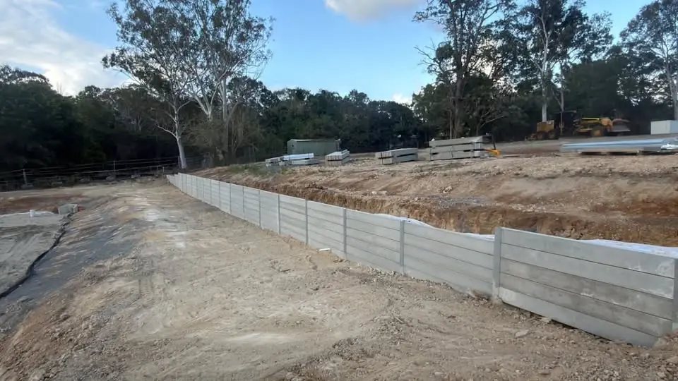A long concrete sleeper retaining wall along a new subdivision