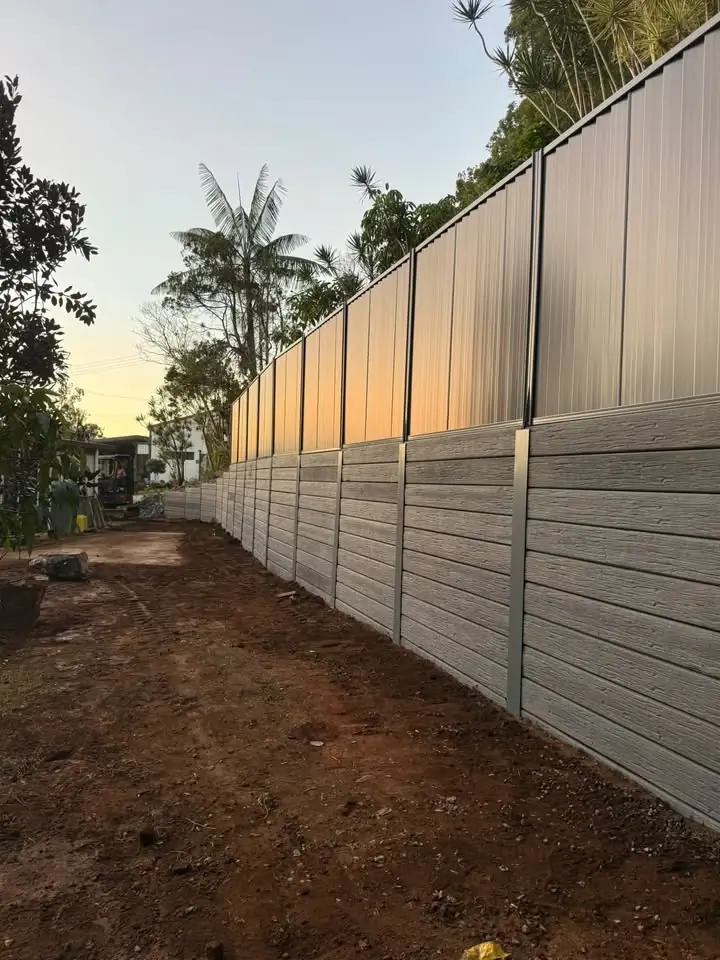 Timber-look concrete sleeper wall with a Colorbond fence on top