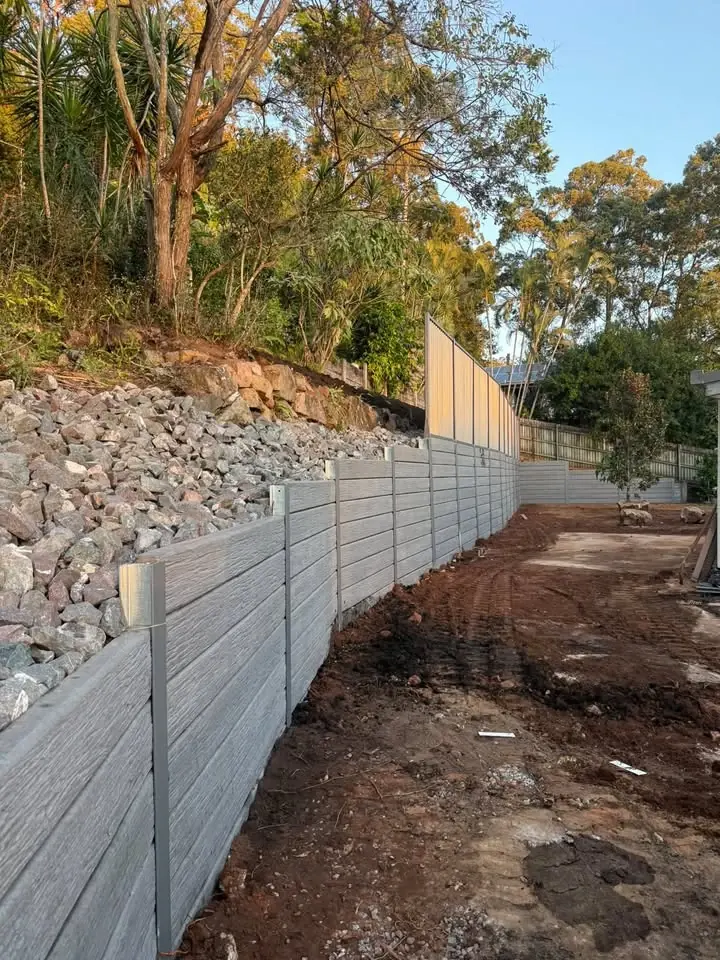 Timber-look sleeper wall with rock beaching above
